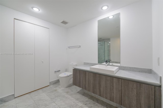 bathroom with vanity, toilet, and a shower with shower door