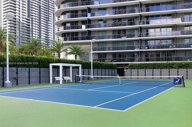 view of tennis court with basketball hoop