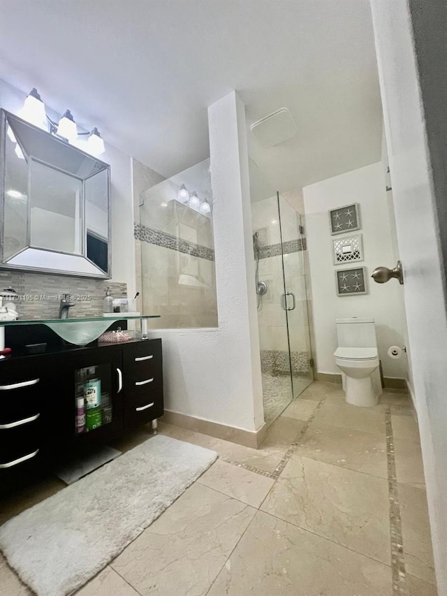 bathroom with backsplash, vanity, a shower with shower door, and toilet