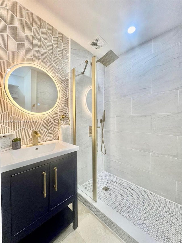 bathroom featuring vanity, tiled shower, and tile walls