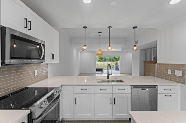 kitchen with white cabinets, decorative backsplash, stainless steel appliances, and sink