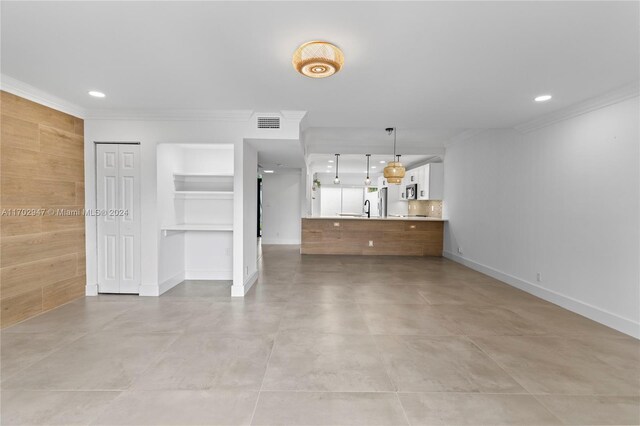 unfurnished living room featuring crown molding