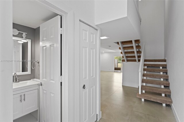 stairway featuring concrete floors and sink