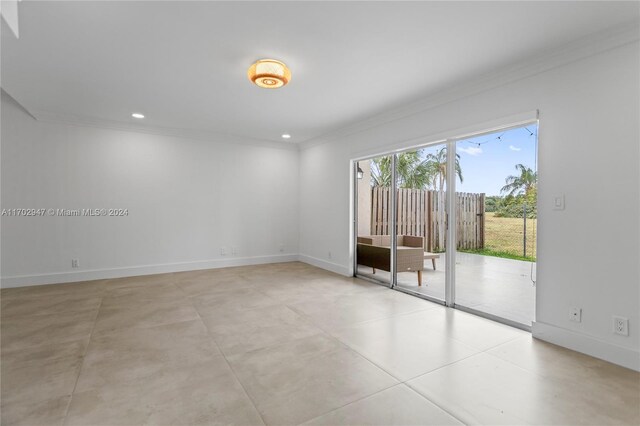 empty room with ornamental molding and light tile patterned floors