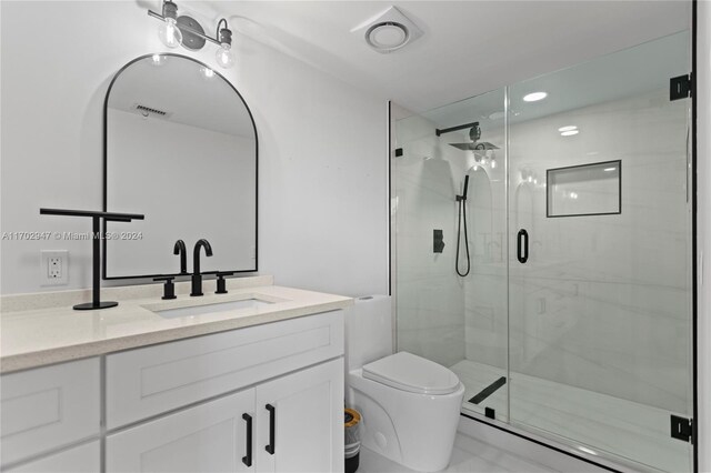 bathroom with vanity, toilet, and an enclosed shower