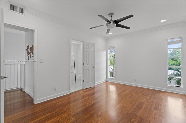 empty room with ceiling fan, dark hardwood / wood-style flooring, and crown molding