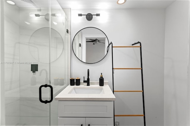 bathroom featuring a shower with door and vanity