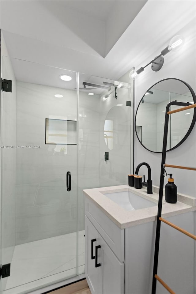 bathroom featuring hardwood / wood-style floors, vanity, and an enclosed shower