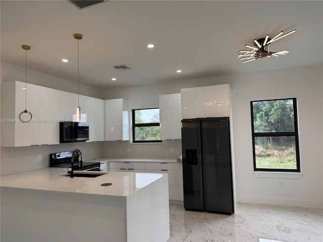 kitchen featuring white cabinets, sink, hanging light fixtures, and black appliances