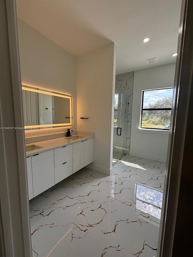 bathroom featuring vanity and a shower with door