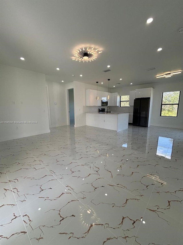 unfurnished living room featuring sink