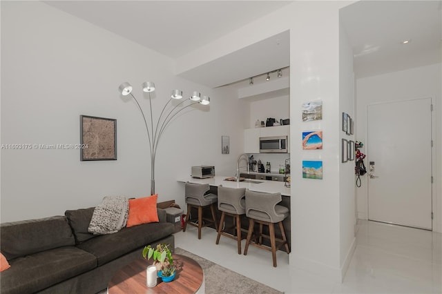 tiled living room with track lighting and sink