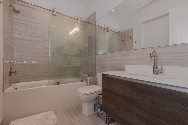 full bathroom featuring vanity, toilet, enclosed tub / shower combo, and tile walls