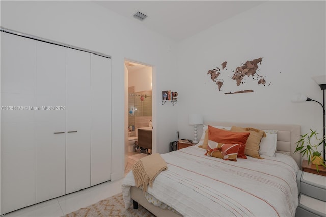 bedroom with ensuite bathroom, a closet, and light tile patterned flooring