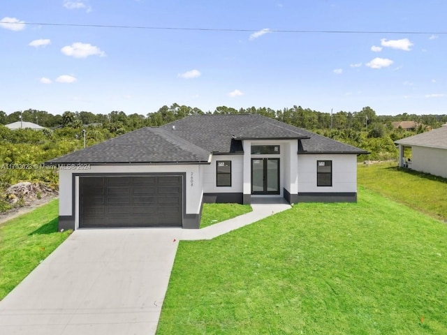 prairie-style home with a garage and a front yard