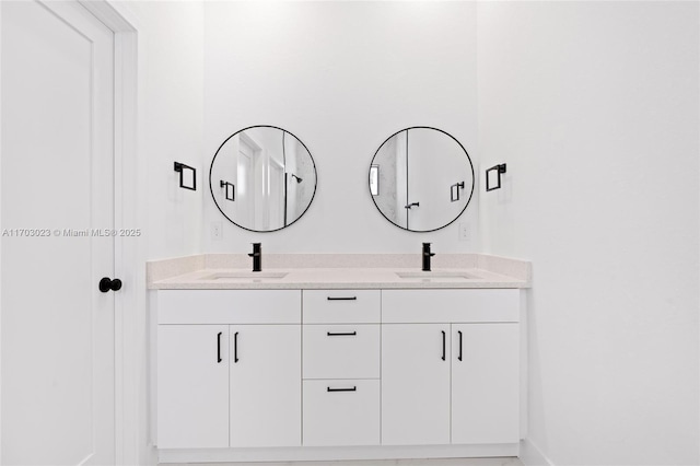 bathroom with double vanity, a sink, and baseboards