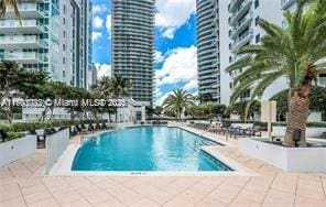 community pool with a view of city and a patio area