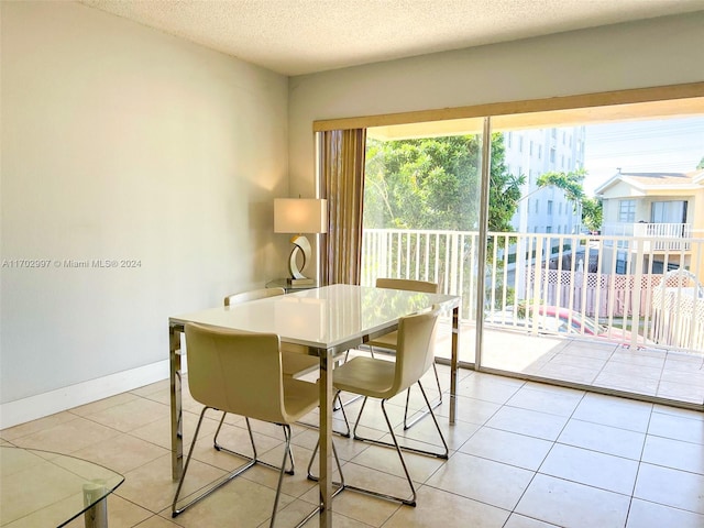 dining space featuring light tile patterned floors and a textured ceiling