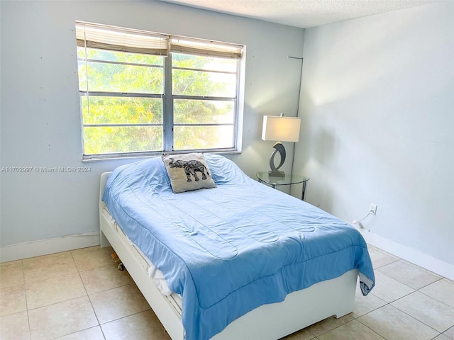 bedroom featuring light tile patterned flooring and a textured ceiling