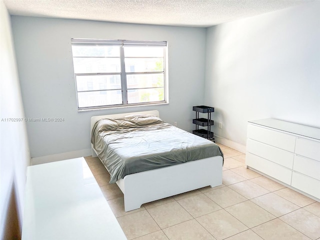 tiled bedroom featuring a textured ceiling