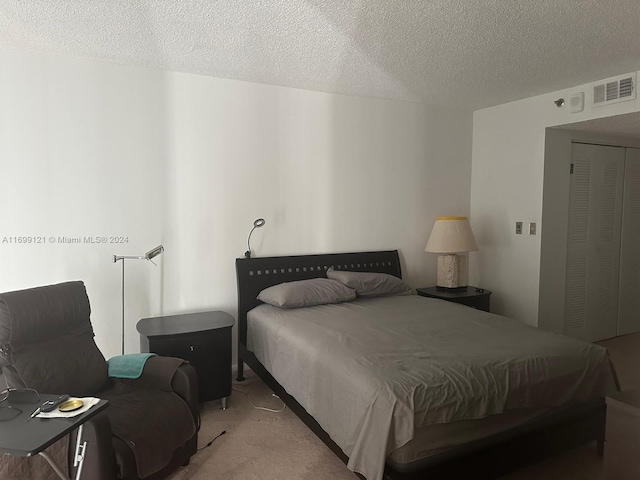 carpeted bedroom with a textured ceiling