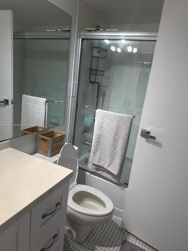 full bathroom featuring tile patterned flooring, vanity, toilet, and shower / bath combination with glass door