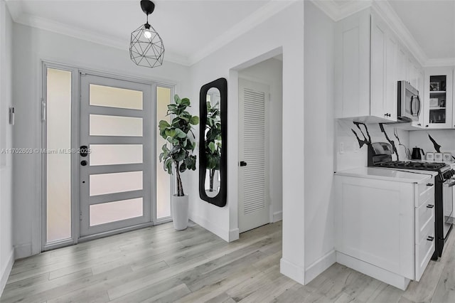 foyer entrance featuring light hardwood / wood-style flooring and crown molding