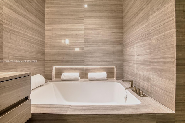 bathroom featuring vanity and a relaxing tiled tub