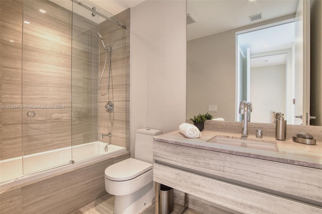 full bathroom with shower / bath combination with glass door, vanity, and toilet