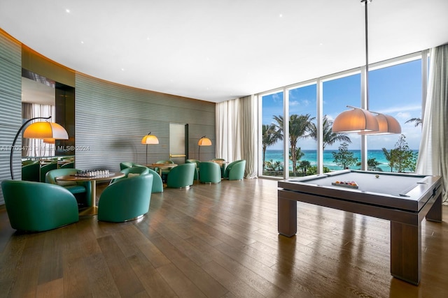 rec room with hardwood / wood-style flooring, a water view, a wall of windows, and billiards