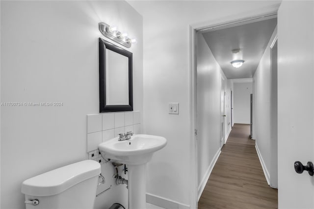 bathroom featuring hardwood / wood-style floors, toilet, and tasteful backsplash