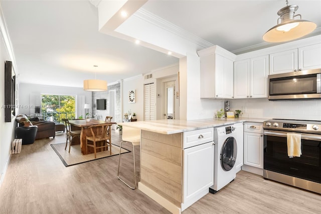 kitchen with white cabinets, washer / dryer, stainless steel appliances, and kitchen peninsula