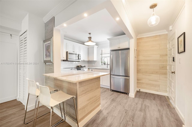 kitchen featuring decorative light fixtures, light stone countertops, white cabinetry, and stainless steel appliances