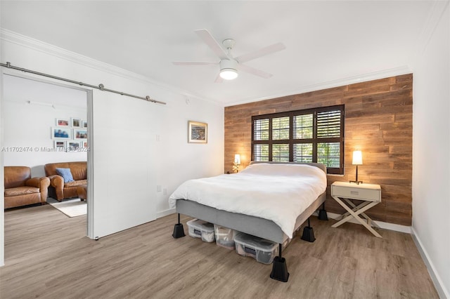 bedroom featuring light hardwood / wood-style floors, ceiling fan, ornamental molding, and wood walls