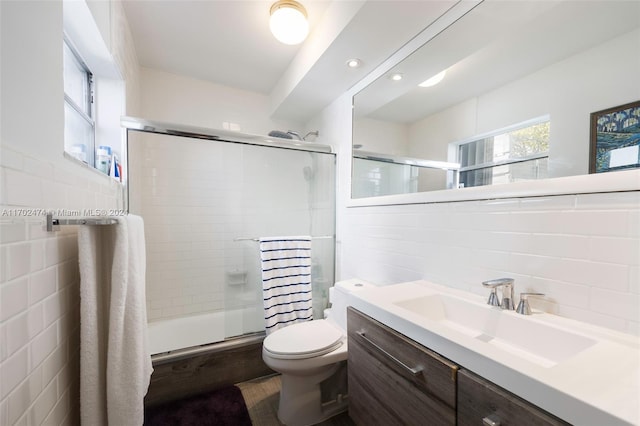 bathroom featuring vanity, an enclosed shower, tile walls, and toilet