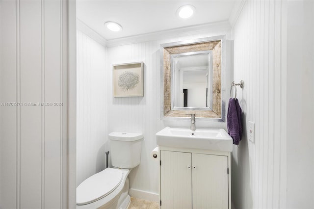 bathroom with vanity, toilet, and ornamental molding