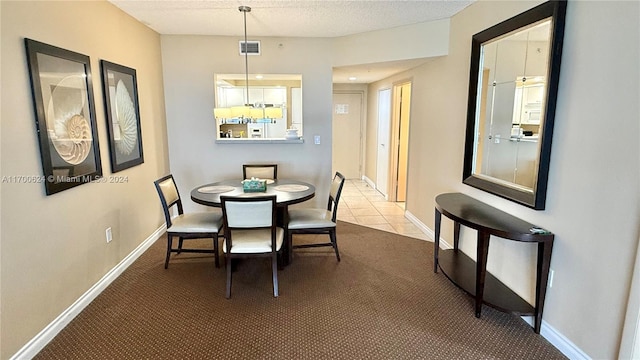 carpeted dining space with a textured ceiling and ceiling fan