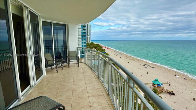 balcony with a water view and a beach view