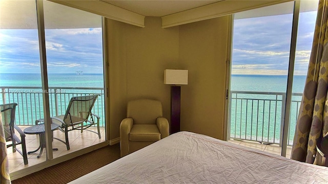 bedroom featuring beamed ceiling, a water view, and multiple windows