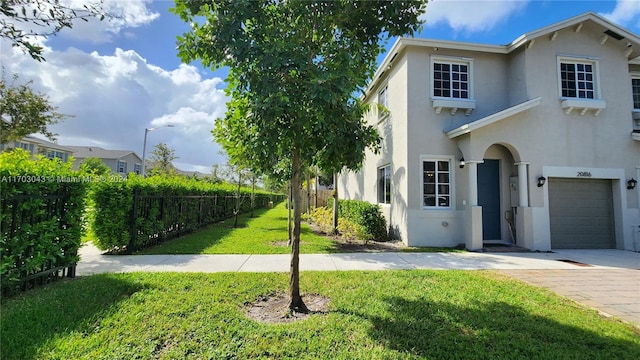 view of front of property with a garage and a front lawn