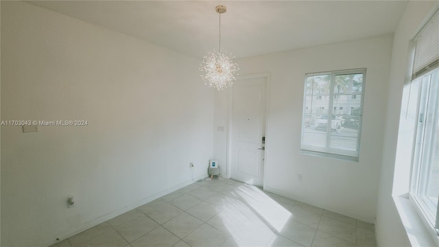 tiled empty room with a chandelier