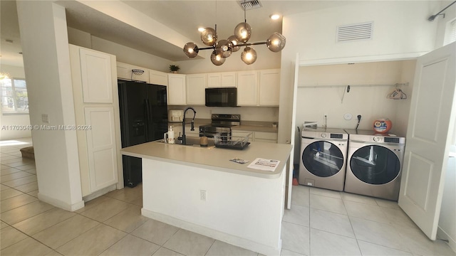 kitchen featuring light tile patterned flooring, washer and dryer, white cabinets, and black appliances