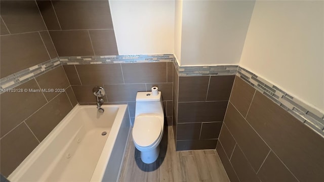 bathroom featuring toilet, tile walls, and a bathing tub