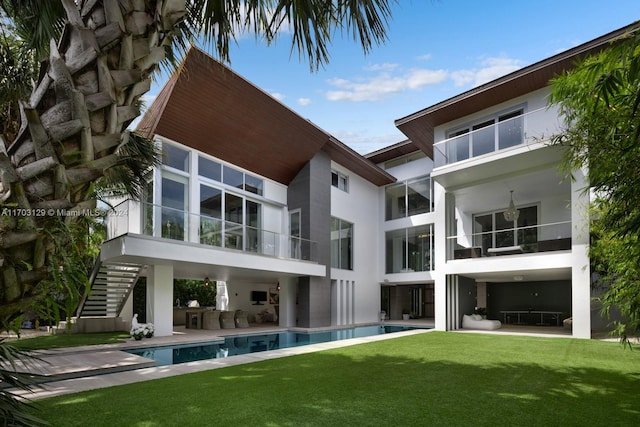 rear view of property with a yard, a patio, and an outdoor kitchen