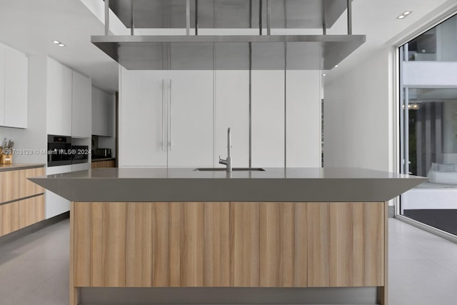 kitchen with a center island, white cabinetry, and sink