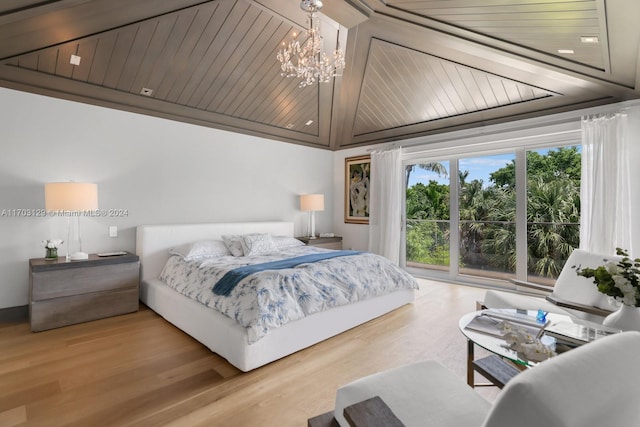 bedroom featuring light hardwood / wood-style flooring, rail lighting, and a notable chandelier