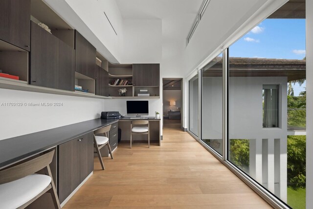 office area with a healthy amount of sunlight, built in desk, and light wood-type flooring