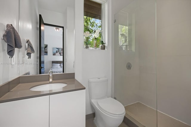 bathroom featuring vanity, toilet, and a tile shower