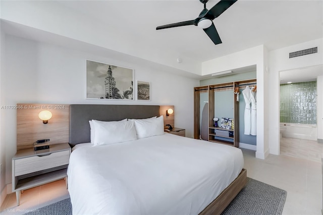 bedroom featuring a closet, ensuite bathroom, ceiling fan, and light tile patterned flooring