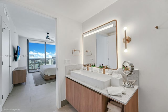 bathroom with floor to ceiling windows, vanity, ceiling fan, and tile patterned flooring